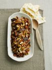 Caponata in dish with wooden spoon and flatbread — Stock Photo