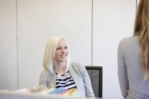 Дві бізнес-леді спілкуються за столом в офісі — стокове фото