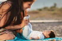 Madre guardando il bambino sdraiato sul tappeto — Foto stock