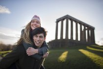 A young couple on Calton Hill with the background of the National Monument of Scotland in Edinburgh — Stock Photo