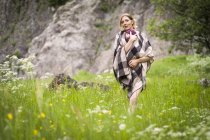 Mother carrying baby girl through meadow — Stock Photo