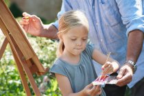 Grandfather and granddaughter painting — Stock Photo