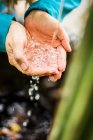 Woman catching water stream in hands — Stock Photo