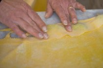 Обрезанный образ женщины, образующей тесто для макарон — стоковое фото
