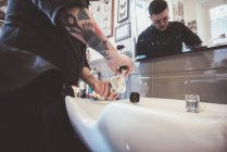 Barbiere preparazione spazzola da barba nel lavandino negozio di barbiere — Foto stock