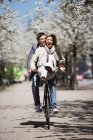 Uomo in sella con fidanzata in bicicletta — Foto stock