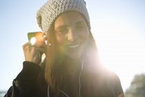 Retrato de jovem mulher usando fones de ouvido ouvindo música — Fotografia de Stock