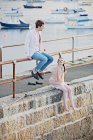 Coppia seduta su ringhiera del porto — Foto stock
