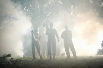 Paintball players in action standing in smoke cloud — Stock Photo
