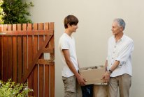 Father and son carrying box together — Stock Photo