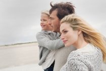 Giovane famiglia sulla spiaggia in autunno — Foto stock