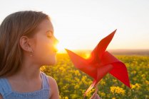 Girl playing with pinwheel outdoors — Stock Photo