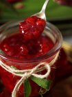 Jar of homemade redcurrant jam and spoon — Stock Photo