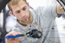 Young man working on bicycle — Stock Photo