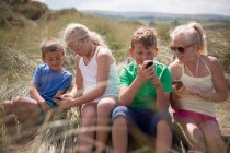 Quatre amis se détendre dans les dunes, Pays de Galles, Royaume-Uni — Photo de stock