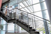 Doctors rushing down hospital staircase — Stock Photo