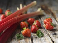 Rhabarber und Erdbeeren mit Minzblättern auf Holzoberfläche — Stockfoto