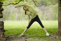 Runner stretching in rural field — Stock Photo