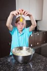 Girl breaking and egg over mixing bowl — Stock Photo