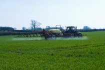Tractor pulling mechanics in crop field — Stock Photo