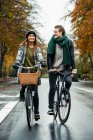 Молодая пара катается на велосипеде по улице — стоковое фото