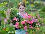 Uma jovem com plantas floridas pote — Fotografia de Stock