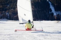 Rückansicht des Eisseglers beim Schlittenfahren über den zugefrorenen See — Stockfoto