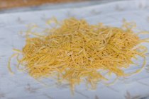 Свіжі шматочки макаронних виробів на стільниці на кухні — стокове фото