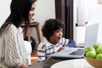 Mãe e filho usando laptop na sala de estar — Fotografia de Stock