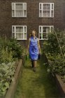 Junge Frau mit Gießkanne auf Kleingartenanlage — Stockfoto