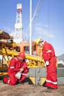 Trabajadores en plataformas petrolíferas que examinan los equipos - foto de stock