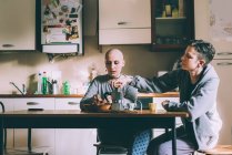 Jovem casal lésbico derramando café expresso na cozinha — Fotografia de Stock