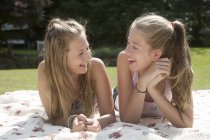 Две девочки-подростки лежат на одеяле для пикника — стоковое фото