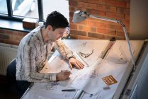 Architect drawing plans at drawing board — Stock Photo