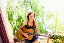 Donna che suona la chitarra sul balcone — Foto stock