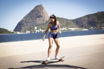 Giovane donna skateboard sul marciapiede — Foto stock