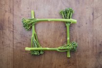 Square made of broccoli on wooden table — Stock Photo