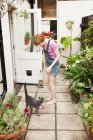 Mujer alimentando gato en el patio trasero - foto de stock