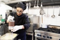 Donna che lavora in cucina ristorante — Foto stock