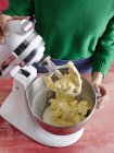 High angle view of mid adult womans mid section using electric mixer — Stock Photo