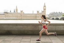 Female runner running on Southbank, London, UK — Stock Photo