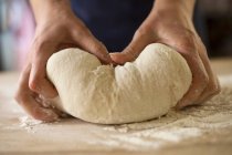Gros plan des mains pétrissant la pâte à pain — Photo de stock