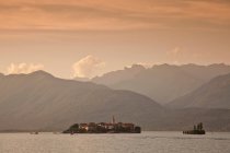 Montagnes sur village rural et lac — Photo de stock