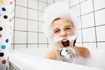 Menino brincando em banho de espuma — Fotografia de Stock