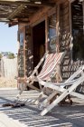 Deckchairs on decking outside beach hut — Stock Photo