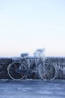 Bicicleta encostada à parede e coberta de gelo — Fotografia de Stock