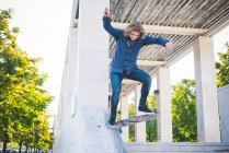 Junge männliche Skateboarder skaten Betonkonstruktion hinunter — Stockfoto