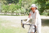 Retrato de ciclista sênior feminino no parque — Fotografia de Stock