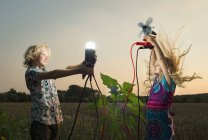Brother and sister generating light from wind power — Stock Photo