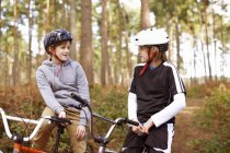 Брати-близнюки на BMX велосипедах спілкуються в лісі — стокове фото